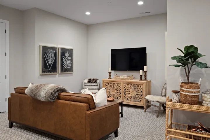 Recessed lighting, light gray walls, white paneled door, and patterned carpeting
