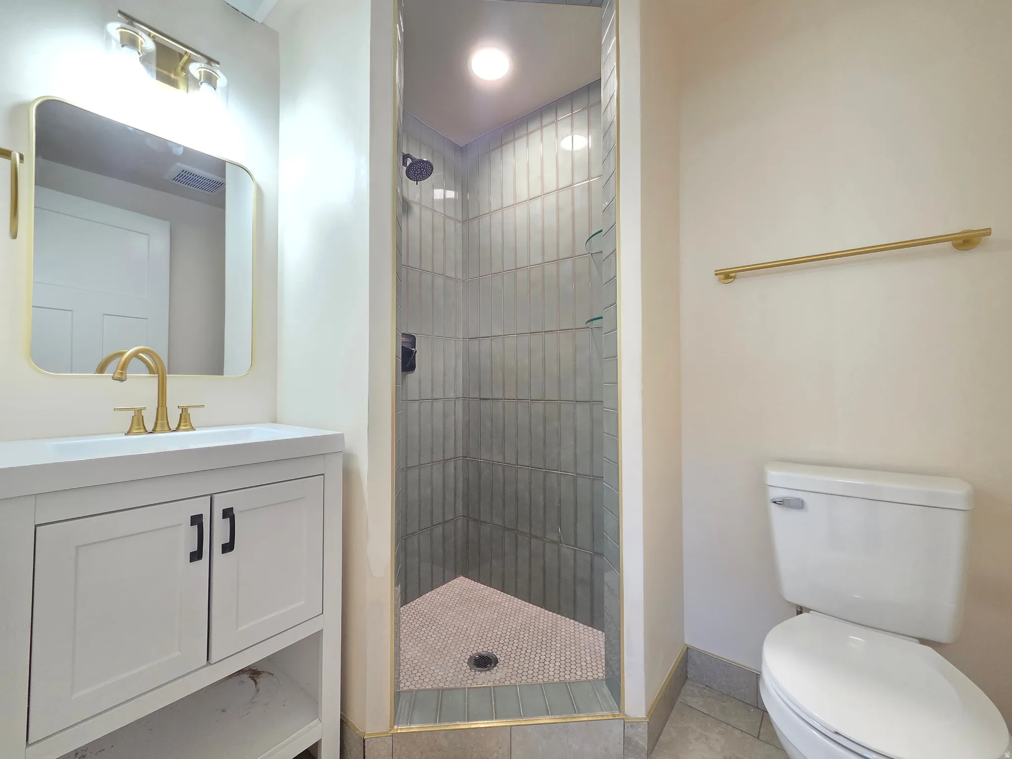 White vanity with integrated sink, gold-finish faucet, and coordinating mirror