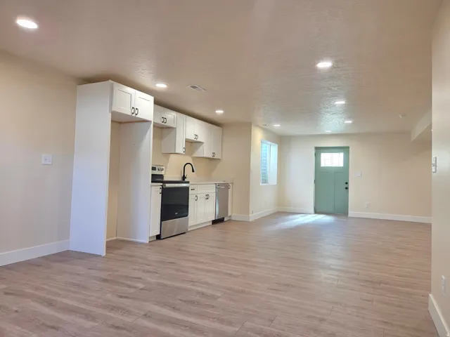 Kitchenette featuring white cabinetry, light wood-finish flooring, stainless steel appliances, and recessed lighting