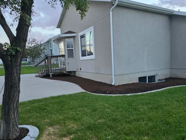 Stucco exterior with white trim, bay window, and a wooden deck with railing