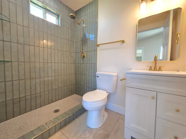 Walk-in shower with vertical subway tile and a built-in bench