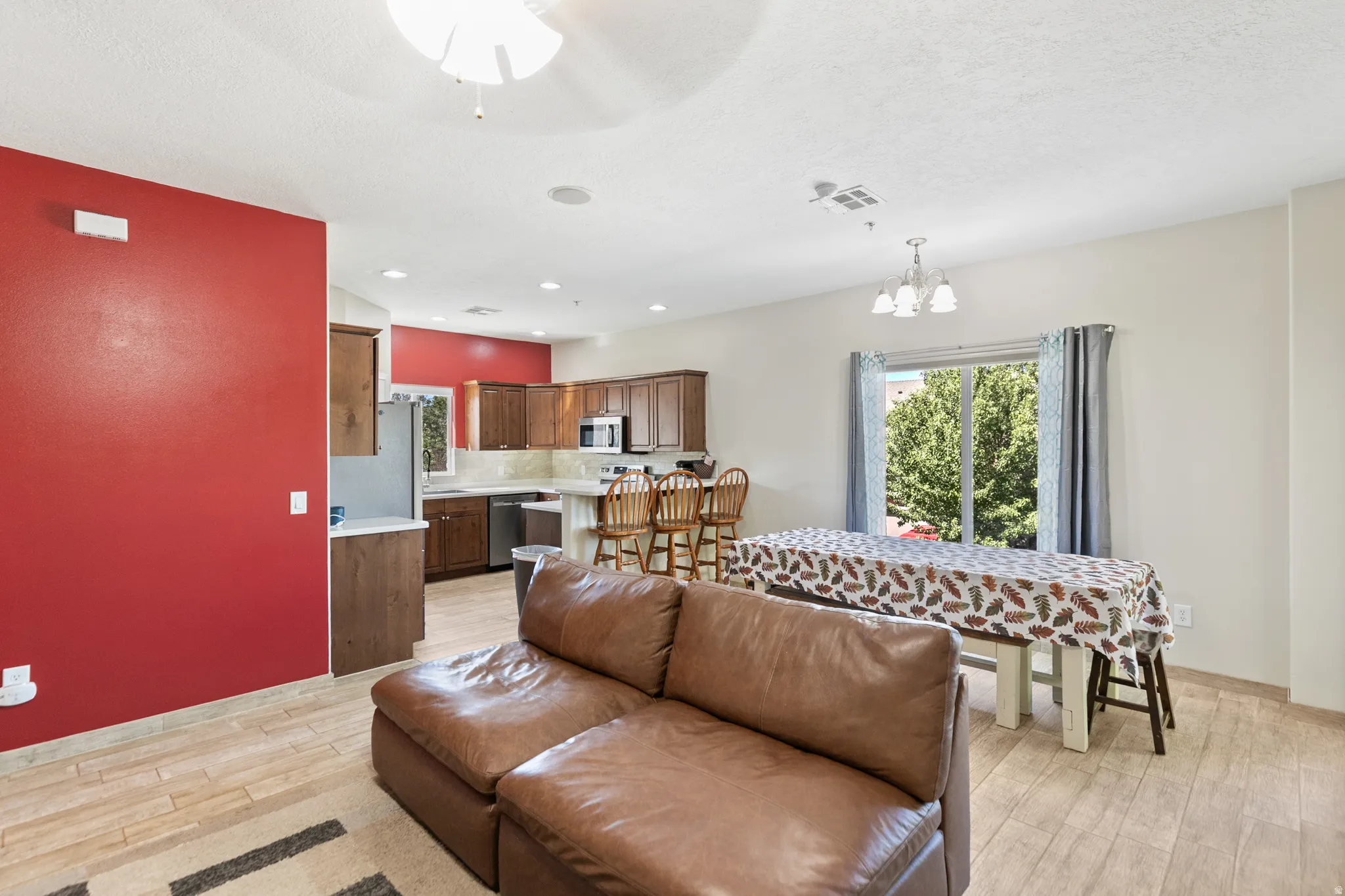 Open-concept living area featuring wood-finish flooring, recessed lighting, and a sliding glass door