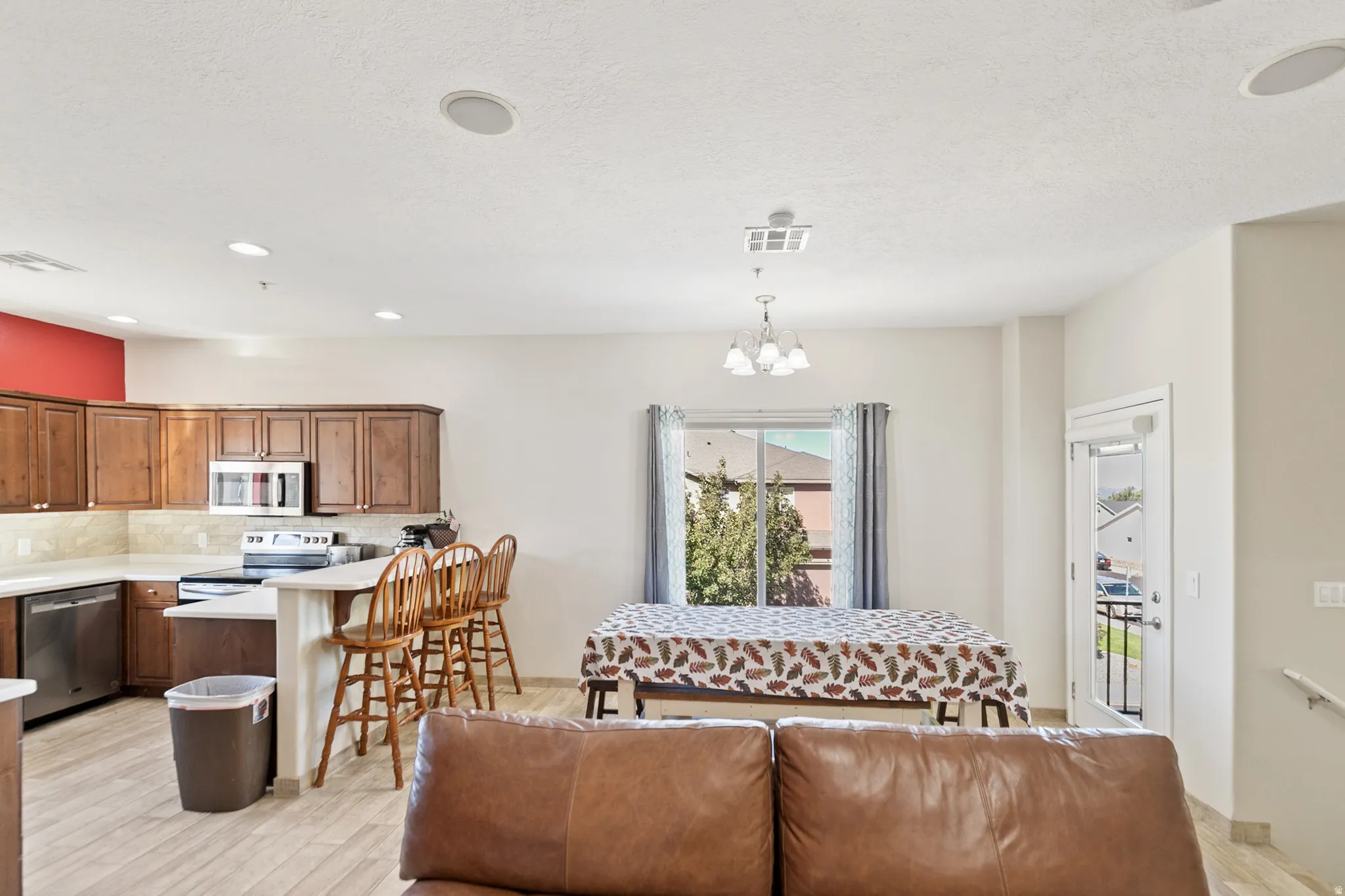 Kitchen featuring wood-finish cabinetry, stainless steel appliances, and light countertops