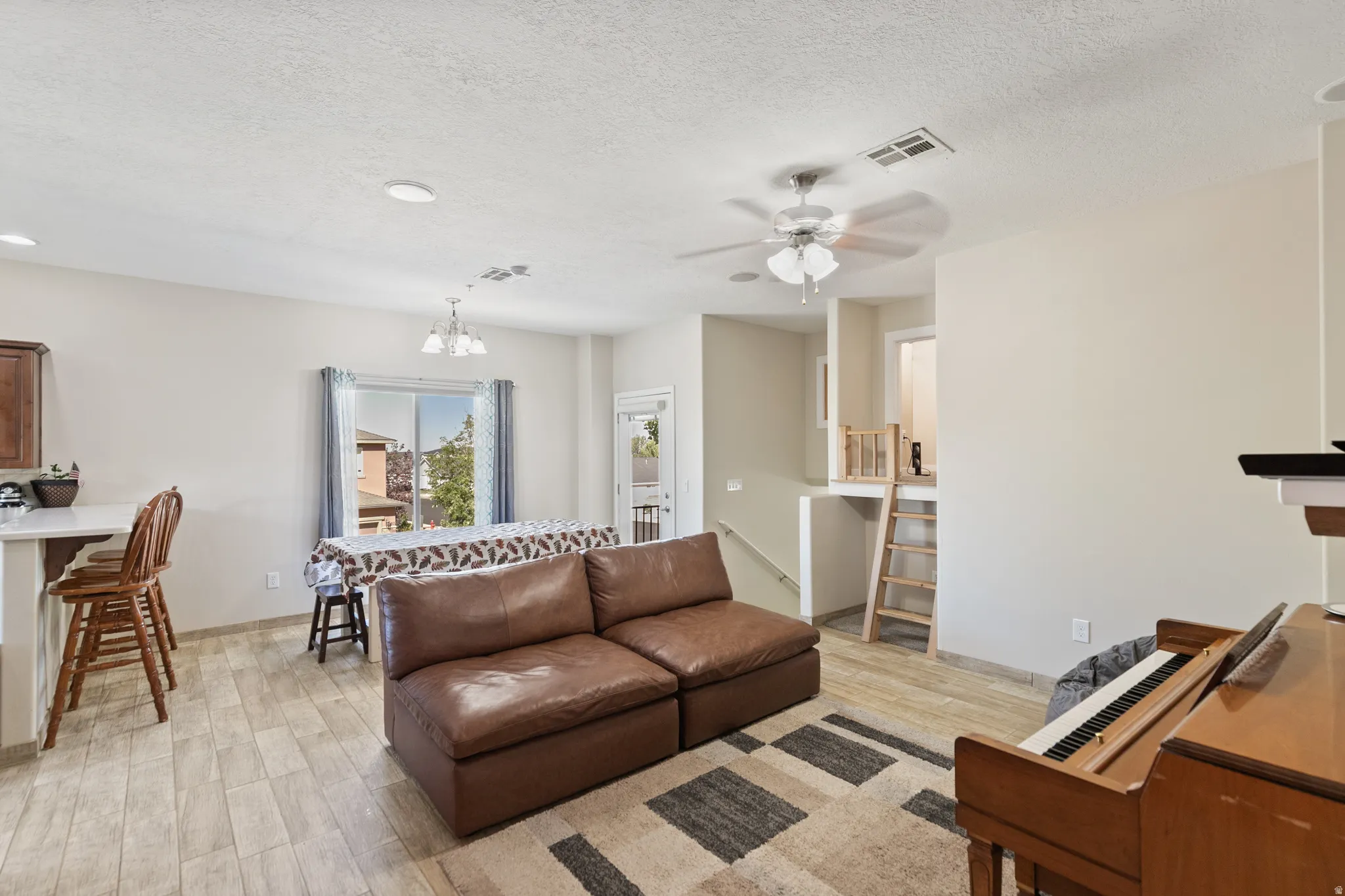 Open-concept living area with wood-finish flooring, recessed lighting, and a ceiling fan