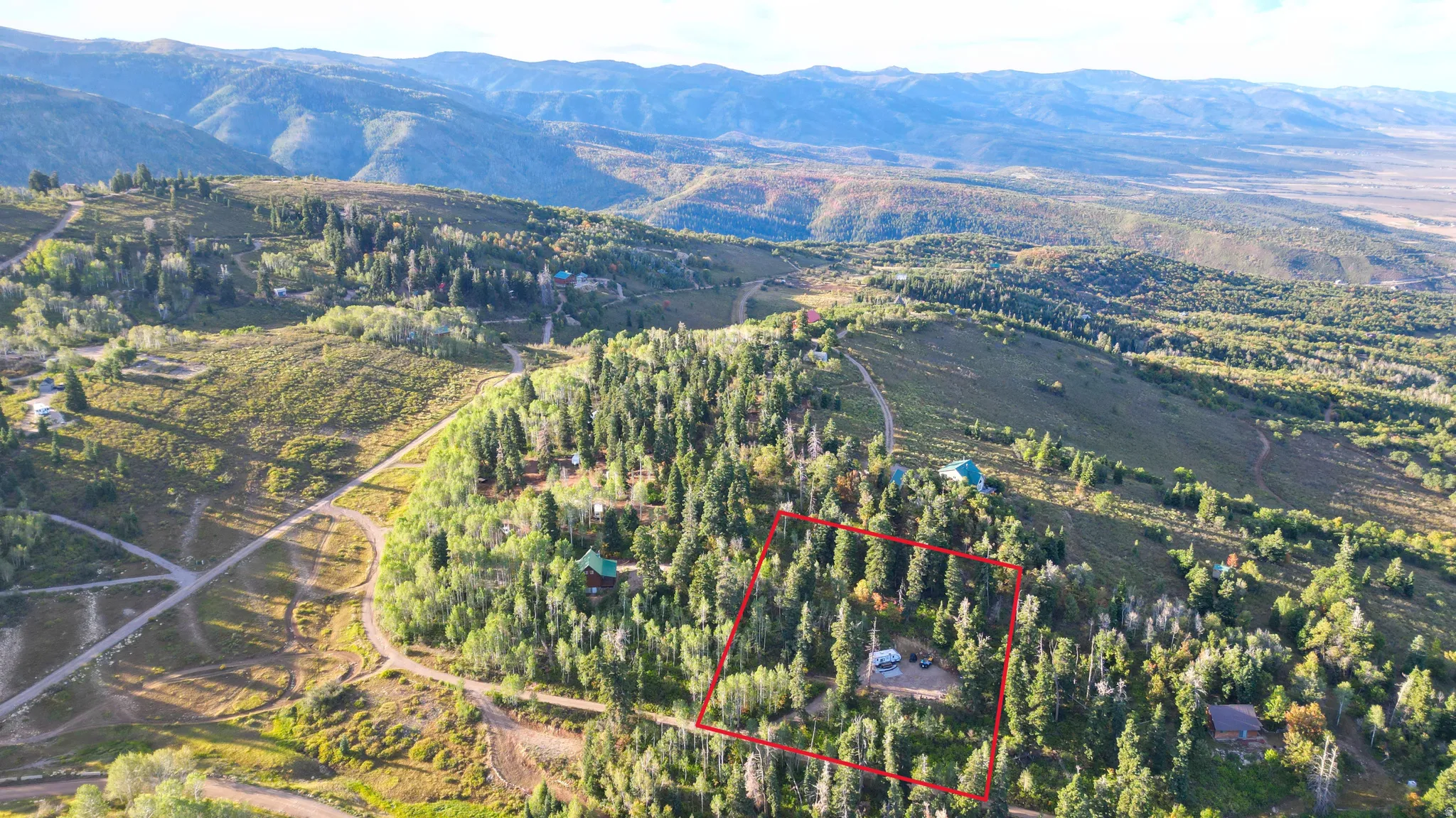 Mountainous terrain with extensive tree coverage and visible structures