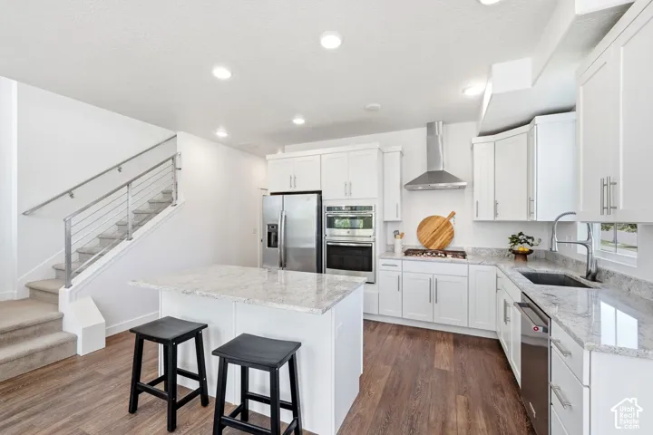 Kitchen featuring white cabinetry, light-toned countertops, stainless steel appliances, and laminate flooring