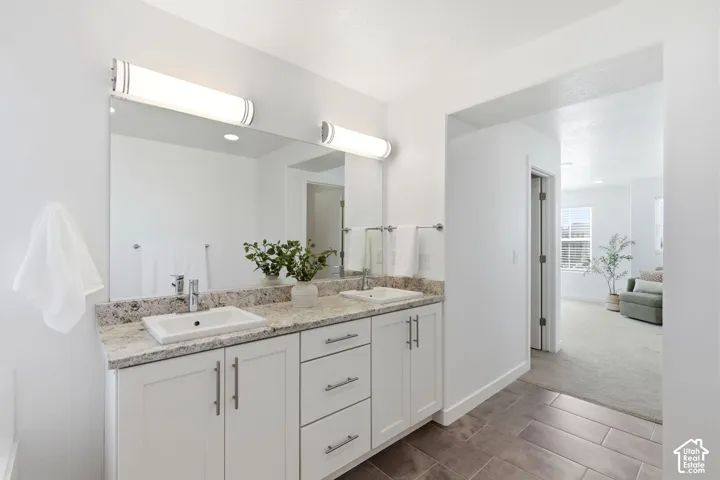 Primary suite bathroom dual vanity with light-toned countertop, rectangular sinks, and chrome fixtures