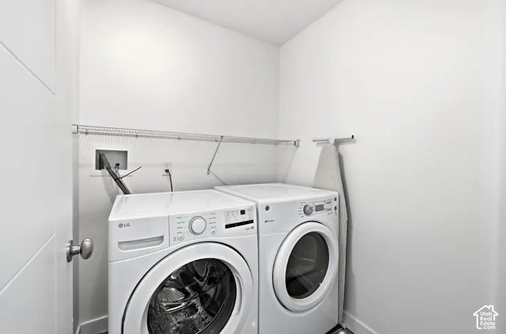 Laundry area featuring a wire shelf, white wall finishes, and a modern door with a satin nickel doorknob