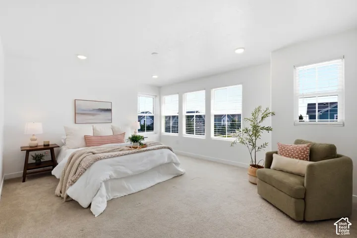 Spacious primary suite featuring neutral carpeting and recessed lighting and tons of windows.
