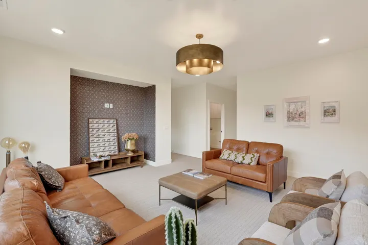 Carpeted flooring, recessed lighting, built-in wall niche with patterned wallpaper, and a drum-style chandelier