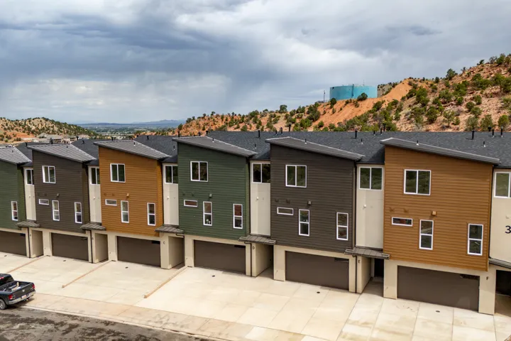 Modern multi-level townhomes with varied facade colors and attached garage spaces