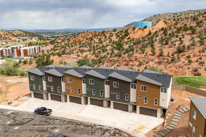 Newly constructed multi-story townhomes with sloped roofs and varied siding