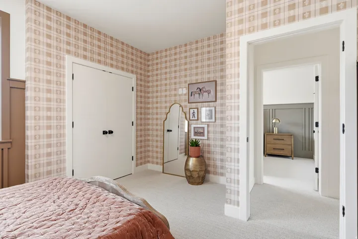 Textured plaid wallpaper, soft carpeting, double-door closet, and white trim accents