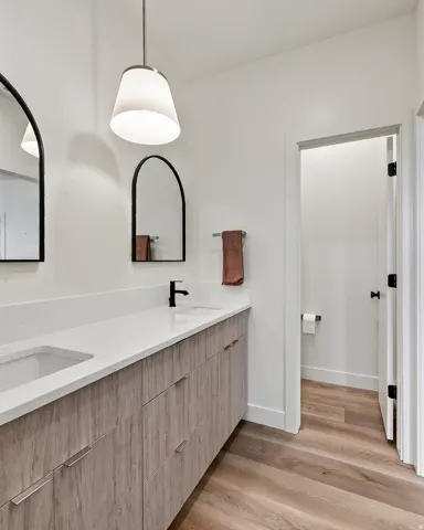Dual vanity featuring wood-finish cabinetry and a light-toned countertop