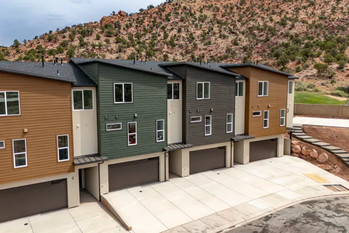 Modern multi-story townhomes featuring varied siding finishes and attached garages