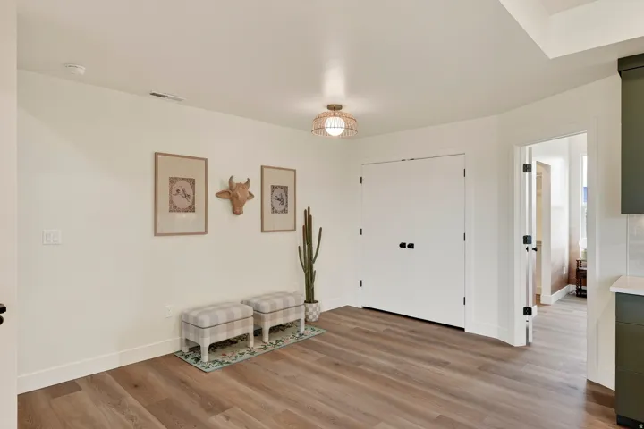 Wood-finish flooring throughout, bright white walls, and a recessed ceiling light fixture