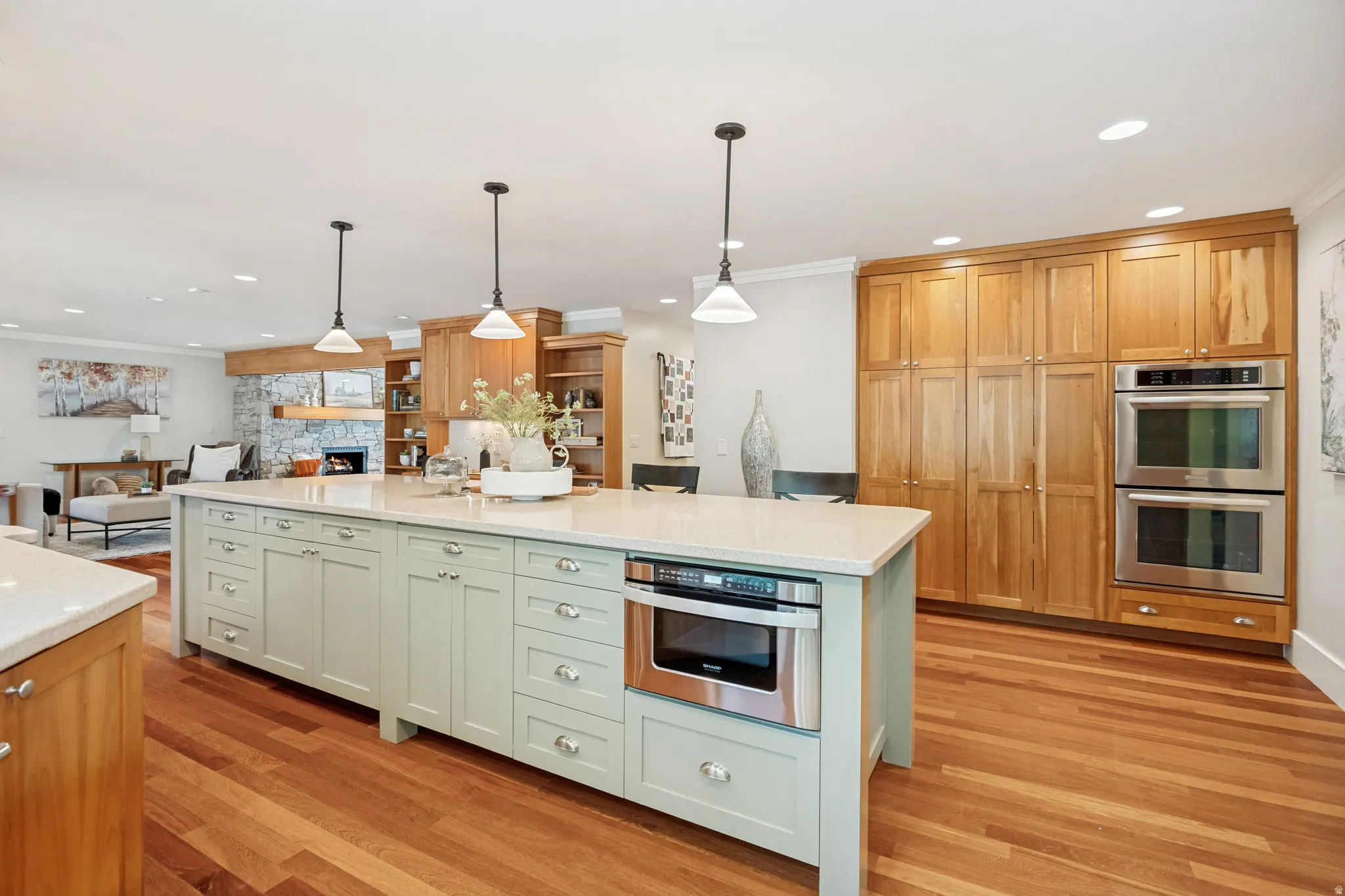 Central kitchen island with light-colored cabinetry and integrated microwave