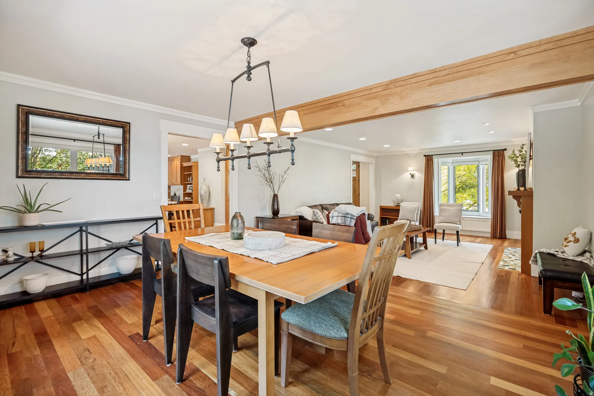 Hardwood flooring throughout, exposed wood beam, recessed lighting, chandelier lighting, and a fireplace with a wood mantle