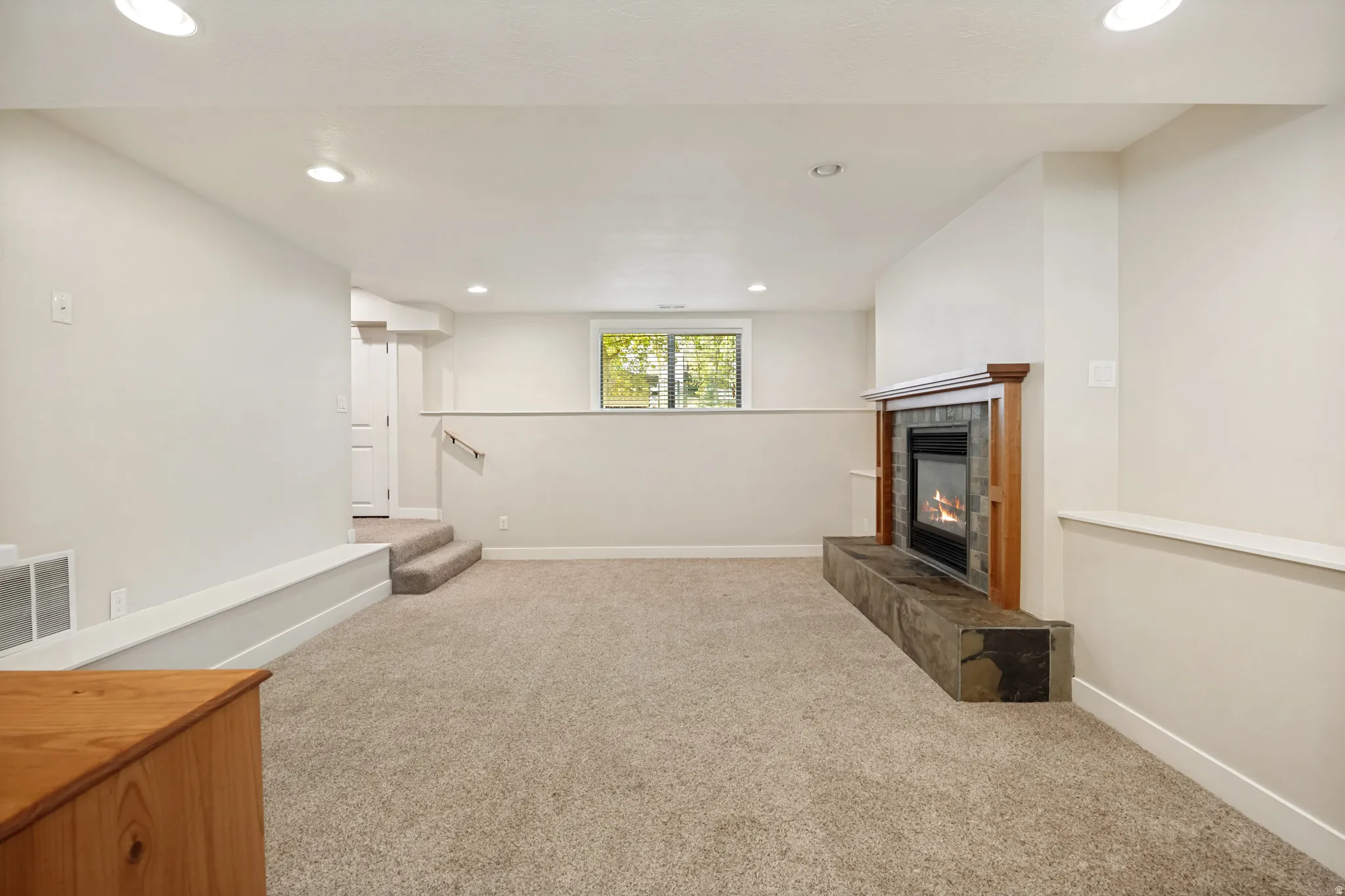 Recessed lighting illuminates the carpeted floor