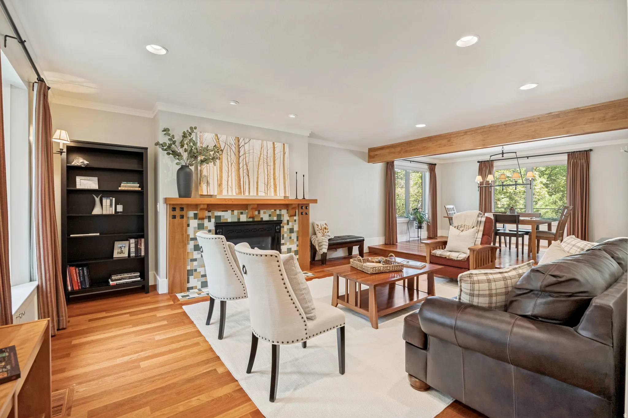 Hardwood flooring, exposed ceiling beam, recessed lighting, fireplace with tile surround and wood mantel, built-in shelving