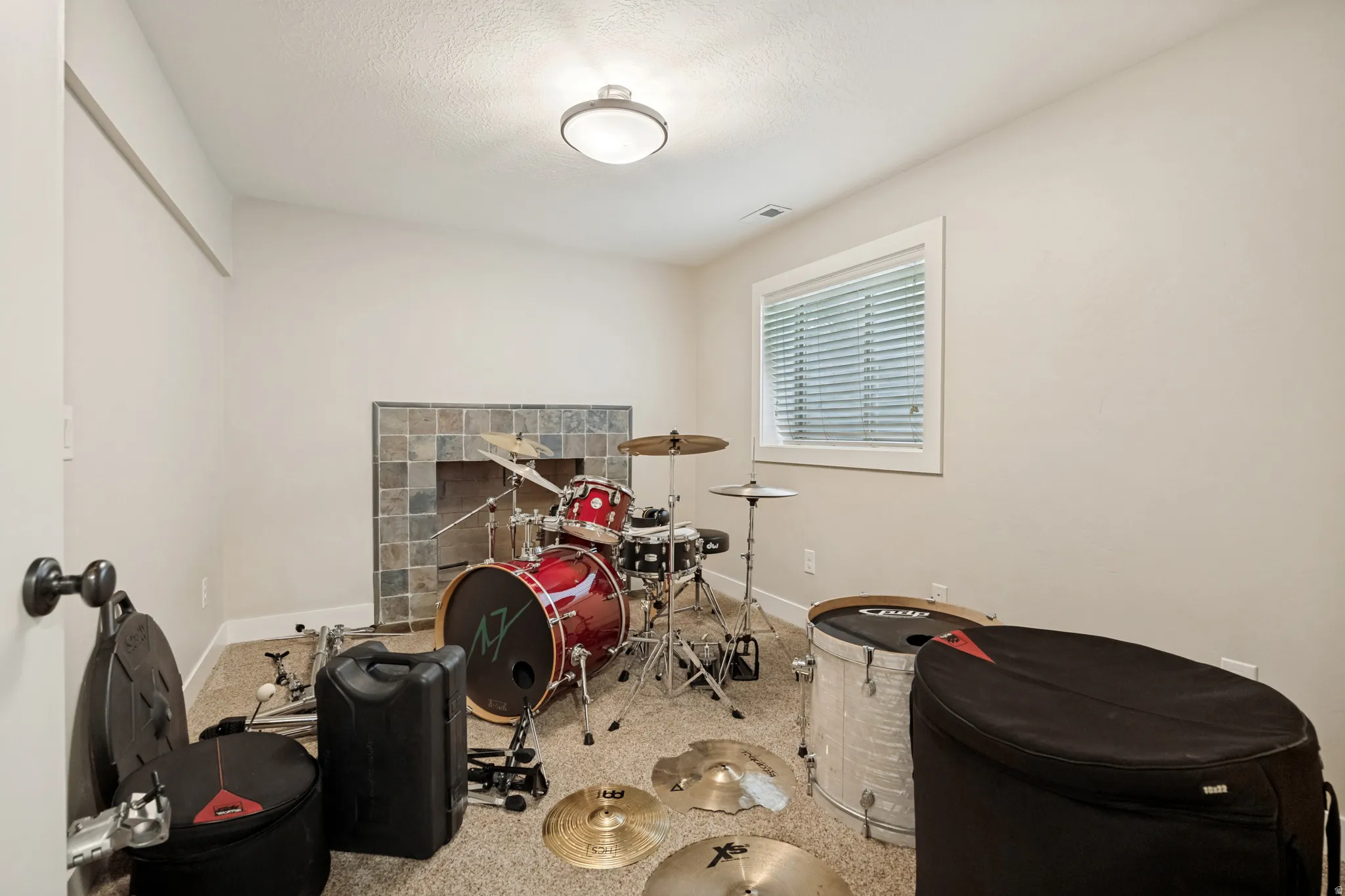 Recessed window with white trim, a flush mount ceiling light, and a stone tile fireplace surround
