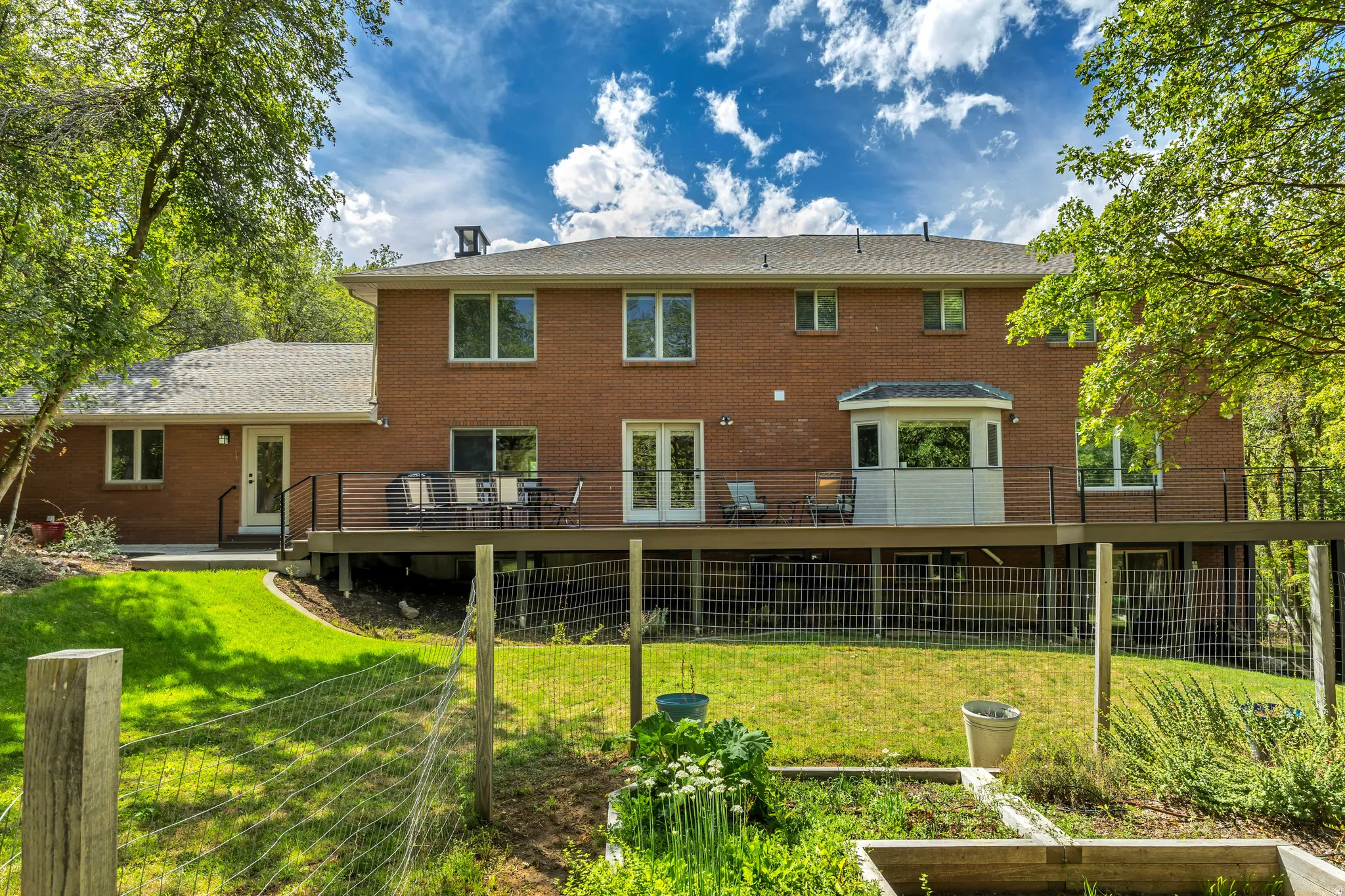 Brick exterior featuring multiple windows and a large elevated deck