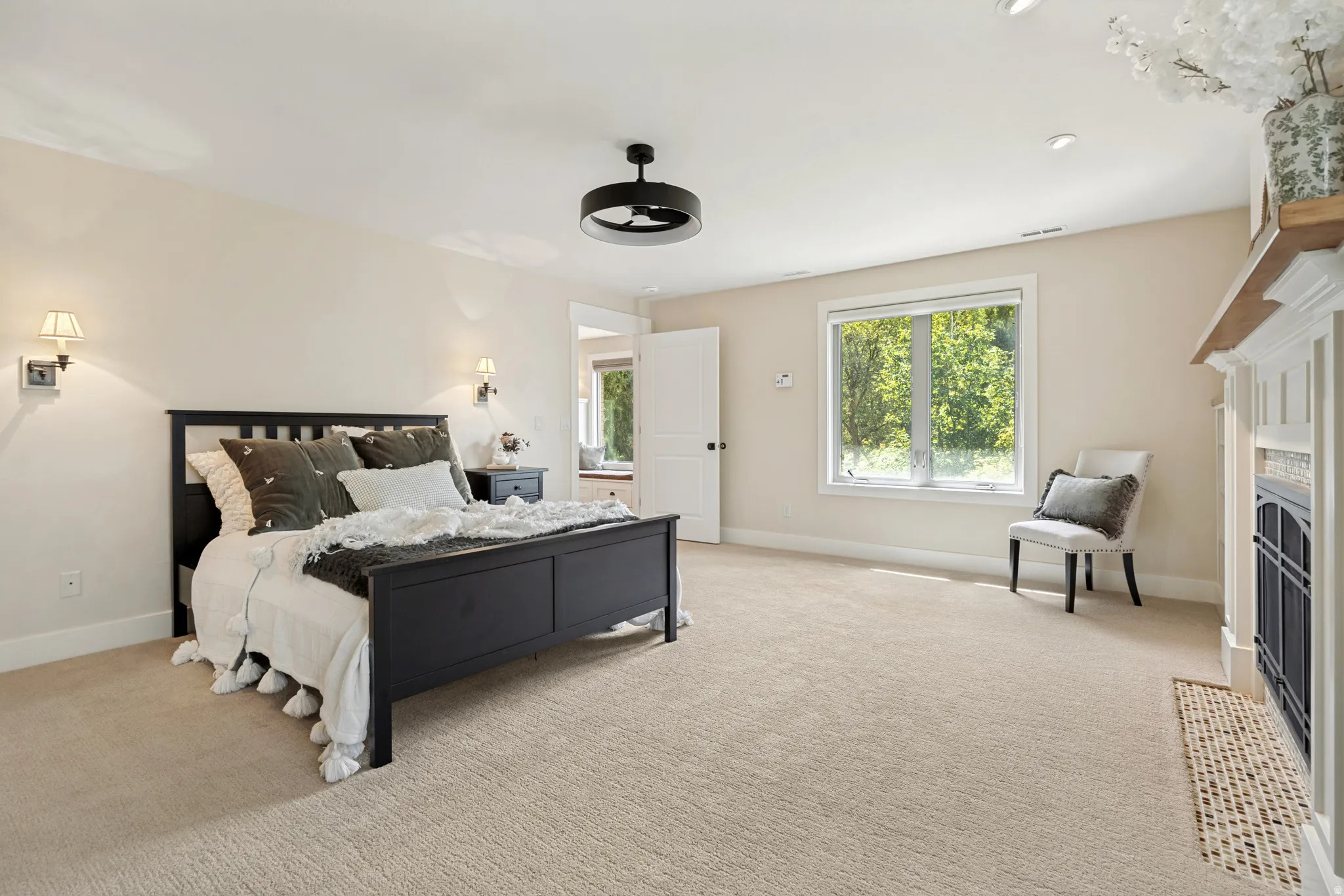 Recessed ceiling lighting, ceiling-mounted light fixture, wall sconces, window with natural light, and fireplace with mantel
