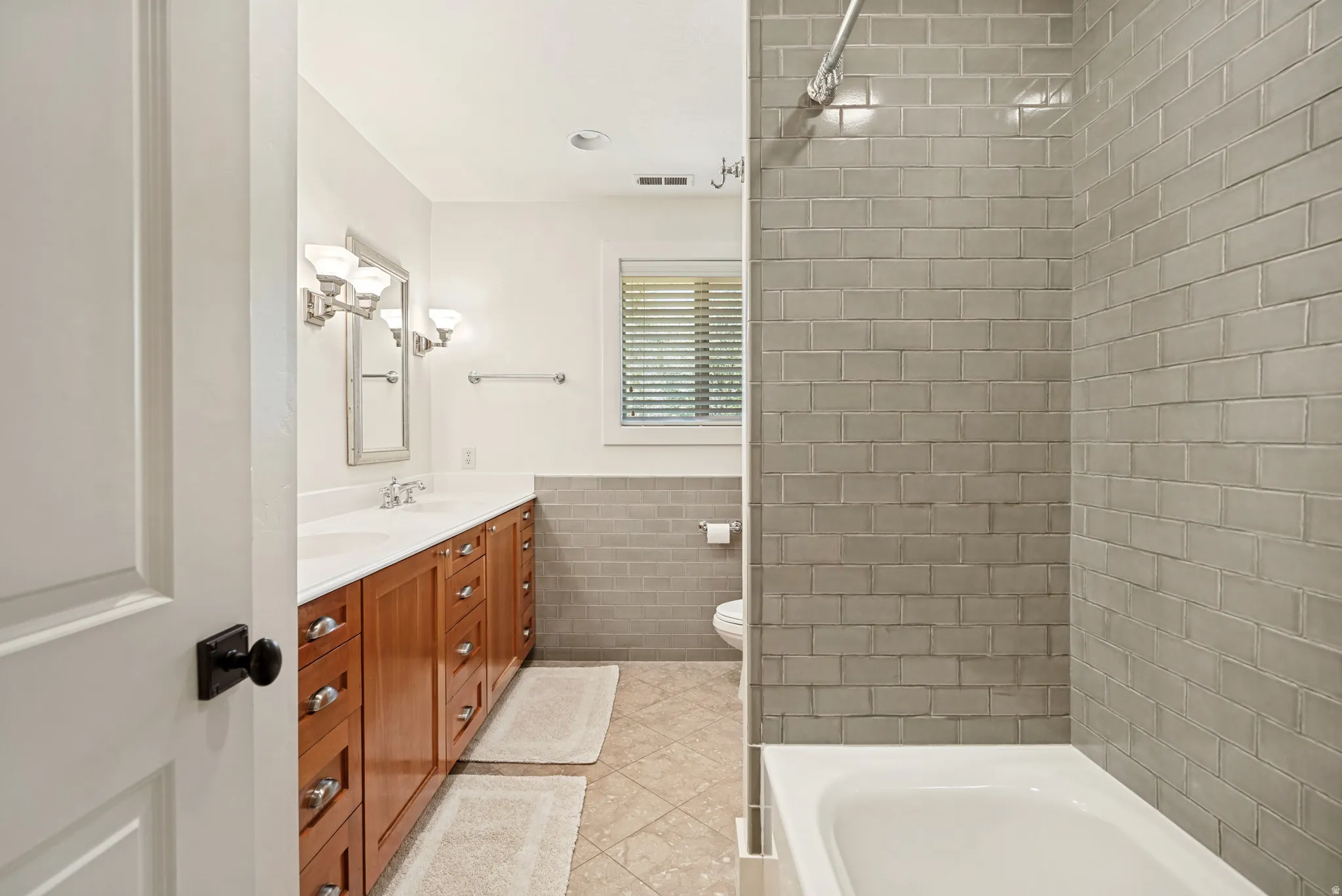 Wood-finish double vanity with dual sinks and white countertops