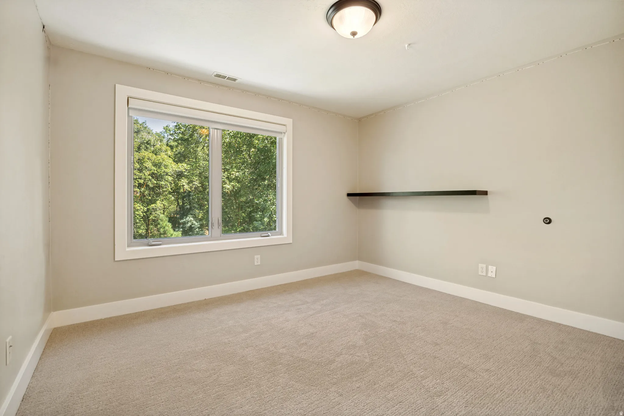 Bright and airy bedroom offering abundant natural light through large double-hung windows framed in white trim