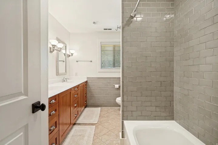 Wood-finish double vanity with dual sinks and white countertops