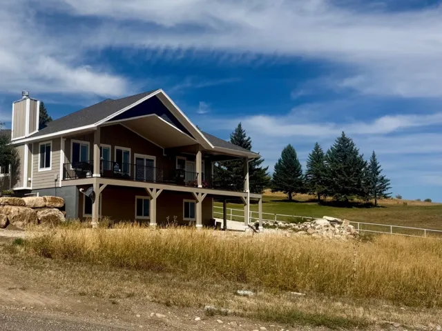 Two-story residence with a covered balcony and lower-level patio