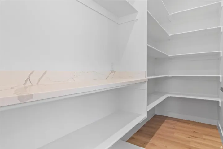 Custom built-in shelving, expansive storage capacity, wood-finish flooring, and a stone-finish countertop