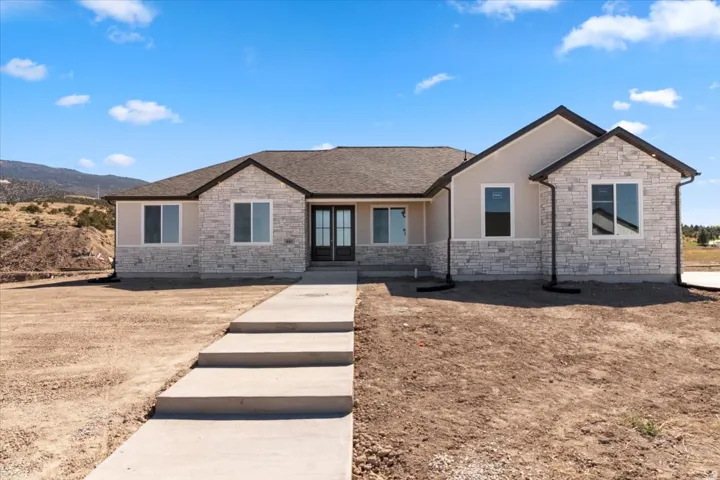 Contemporary exterior with stone facade accents and light-toned siding