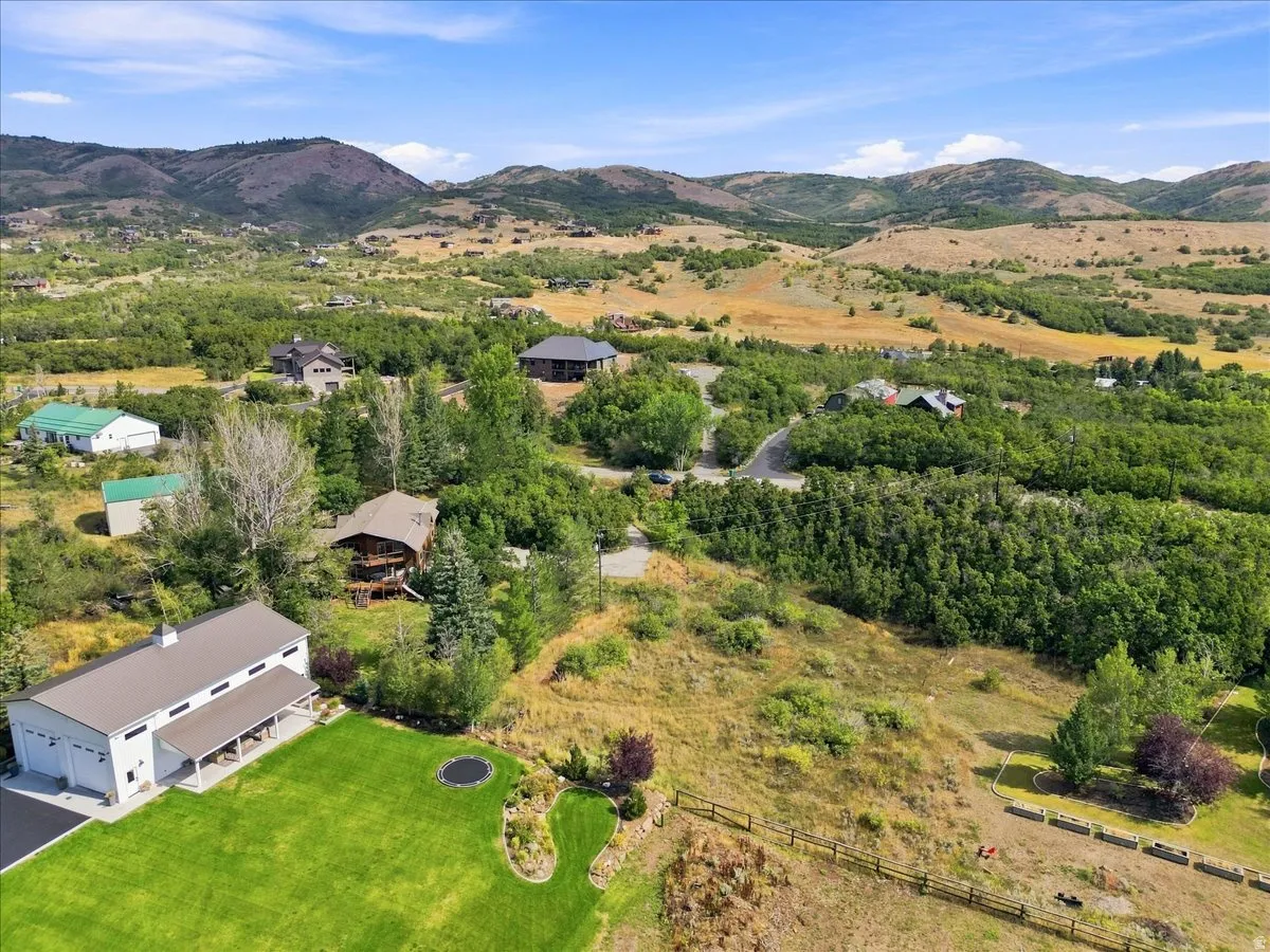 Expansive property featuring a large detached garage with multiple bays, a covered porch, and a manicured lawn