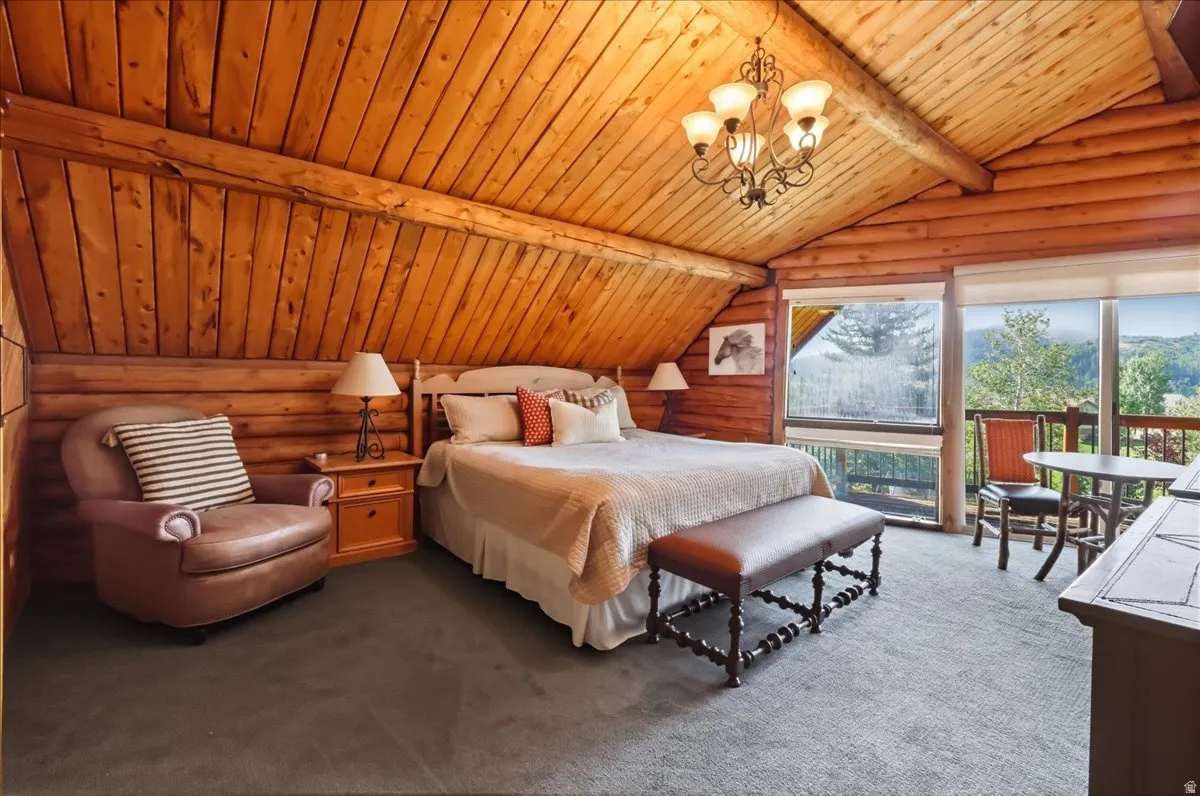 Tongue-and-groove wood paneling on walls and vaulted ceiling, exposed wood beams, and expansive windows