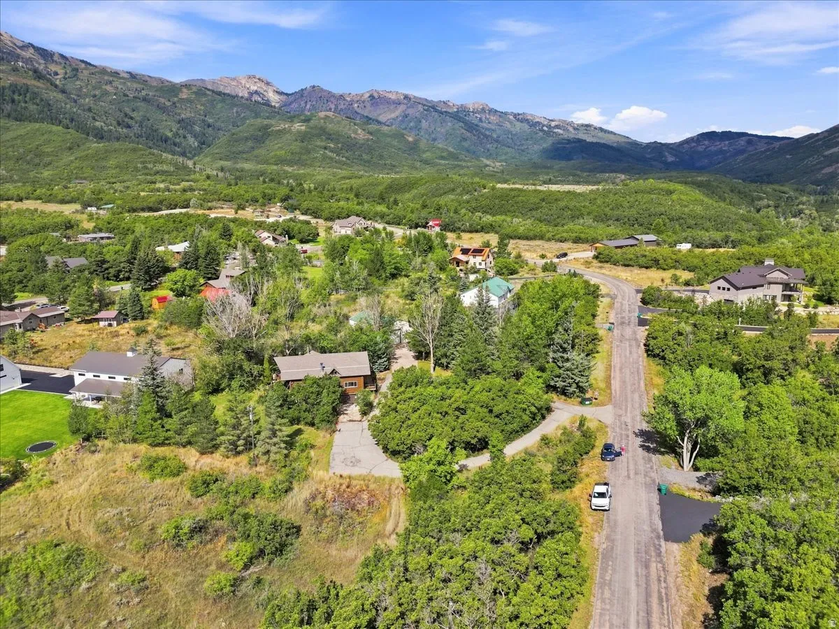 Mountainous terrain surrounding a residential area with lush green trees and natural landscaping