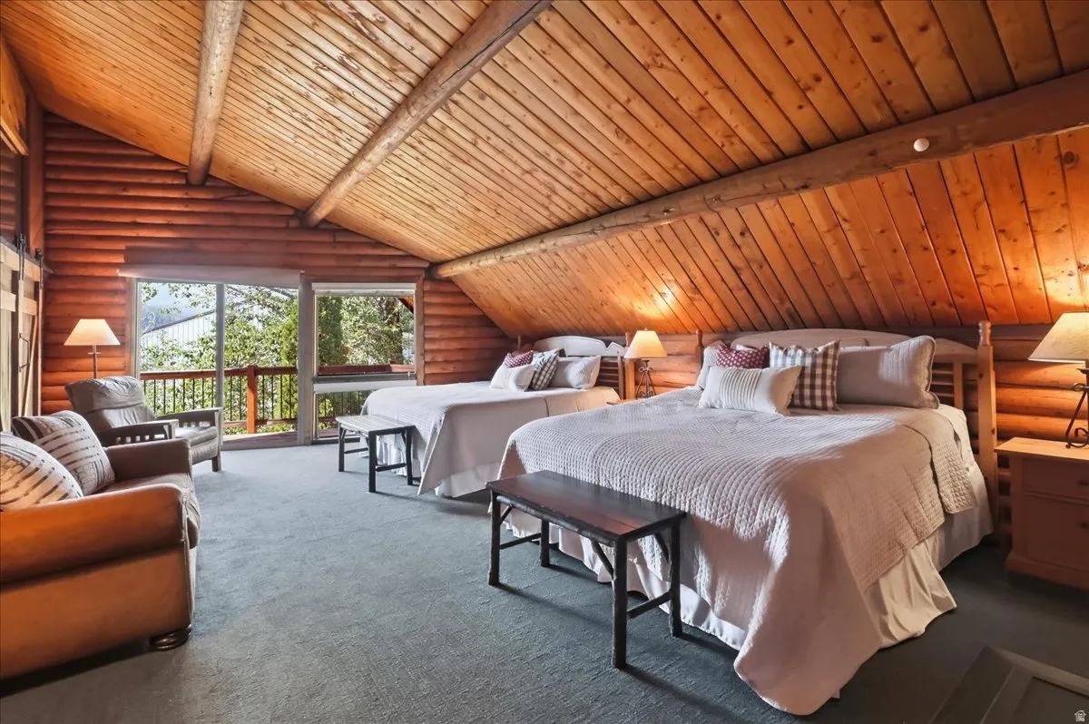 Vaulted wood-paneled ceiling, wood-plank walls, full-light glass door, private balcony, and light-toned carpeting