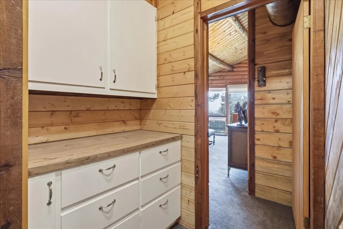 Natural wood paneling throughout, built-in white cabinetry with ample storage, and wood-finish countertop