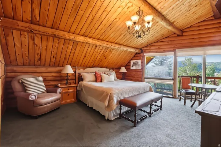 Tongue-and-groove wood paneling on walls and vaulted ceiling, exposed wood beams, and expansive windows