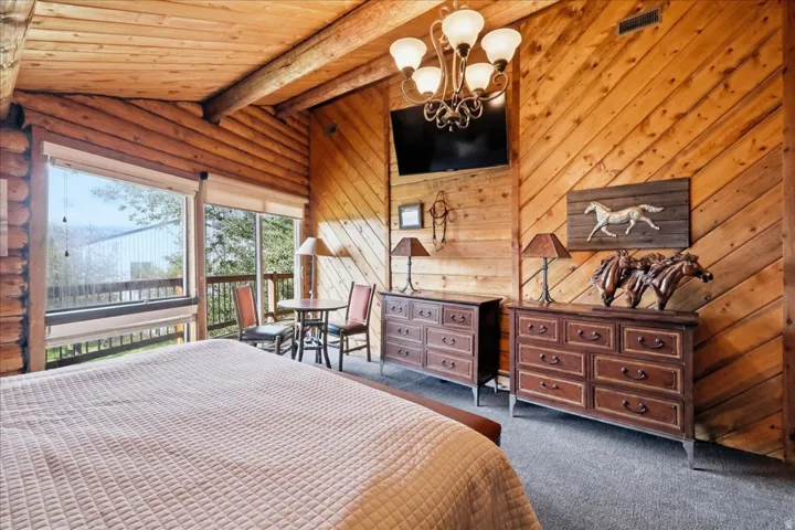 Wood-paneled walls and ceiling, large windows, and a private balcony