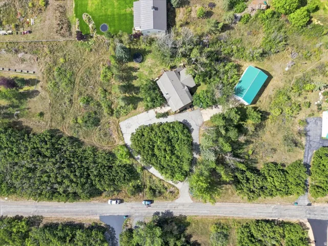 Expansive property with a central residence, detached building, and a paved circular driveway