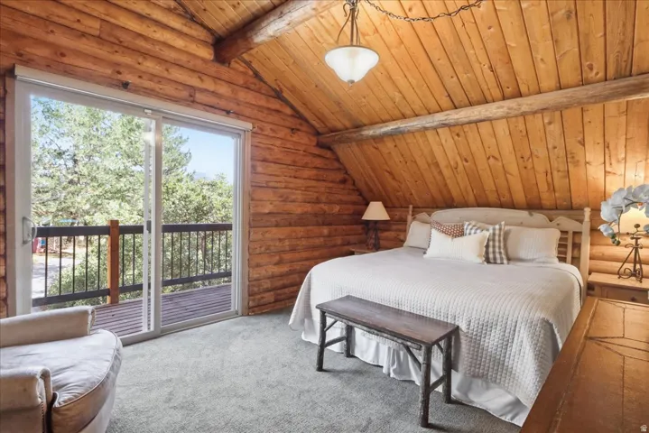 Log walls and vaulted wood-paneled ceilings, complemented by plush carpeting