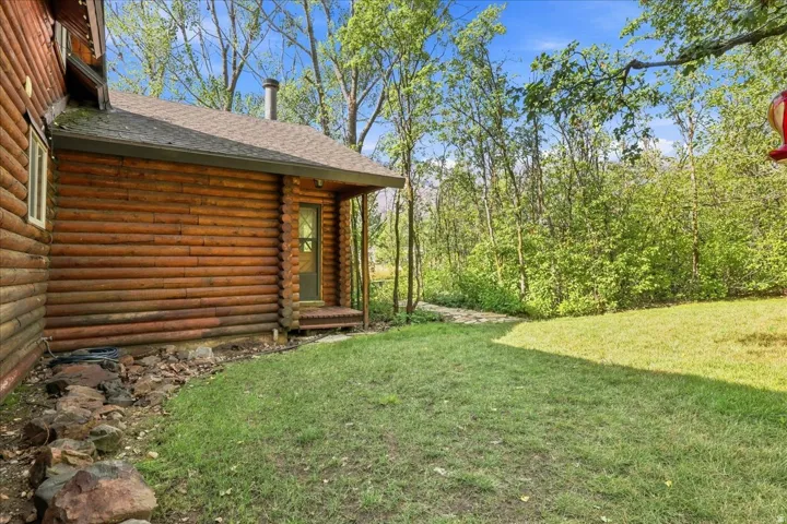 Log-style exterior with wood siding and a covered porch entry