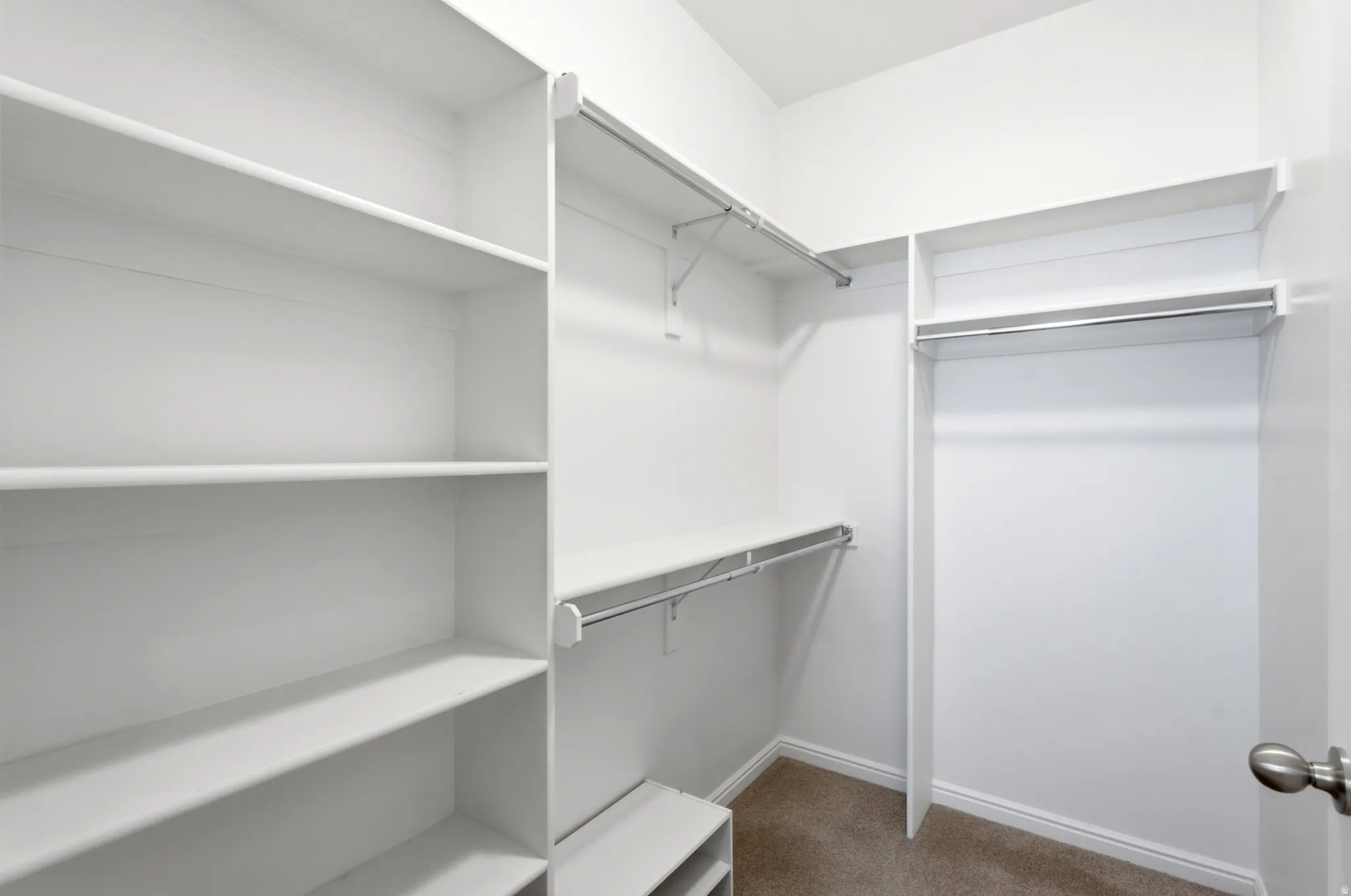 Built-in closet organization system featuring multiple shelving units and hanging rods