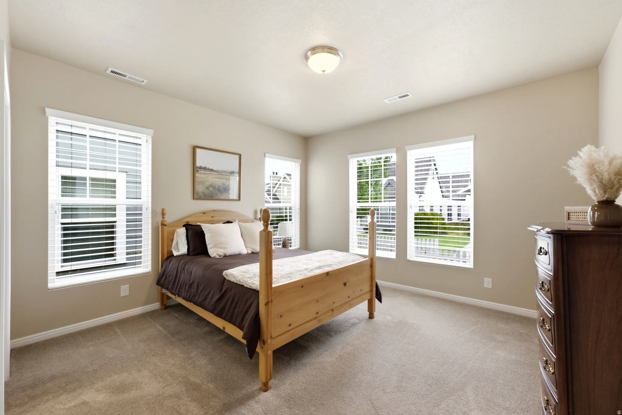 Neutral wall colors, recessed lighting, and soft carpet flooring