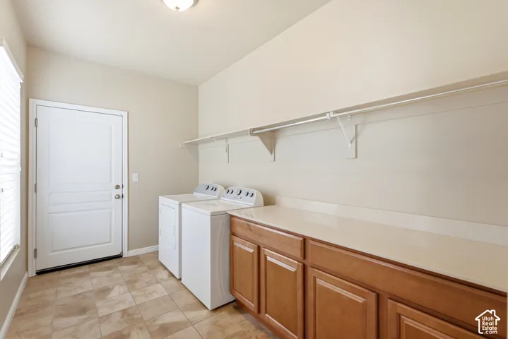 Tile flooring, wood-finish cabinetry, solid surface countertop, white shelving, and a prominent window with blinds