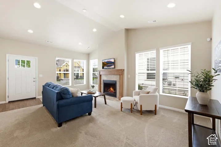 Vaulted ceiling, recessed lighting, wood-finish flooring, fireplace with wood mantel, multiple windows with blinds
