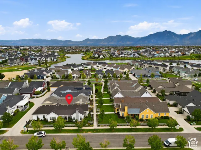 Aerial perspective of a residential neighborhood with a prominent lake and distant mountains