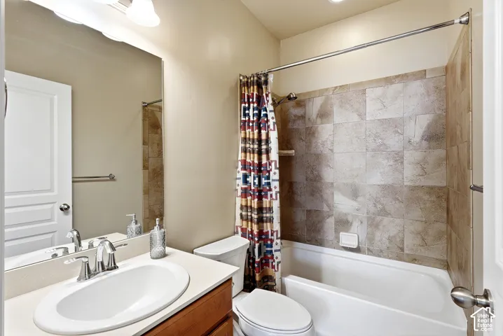 Vanity with integral sink, chrome faucet, wood-finish cabinetry, and a full-width mirror