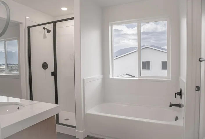 Primary bathroom featuring separate tub and shower